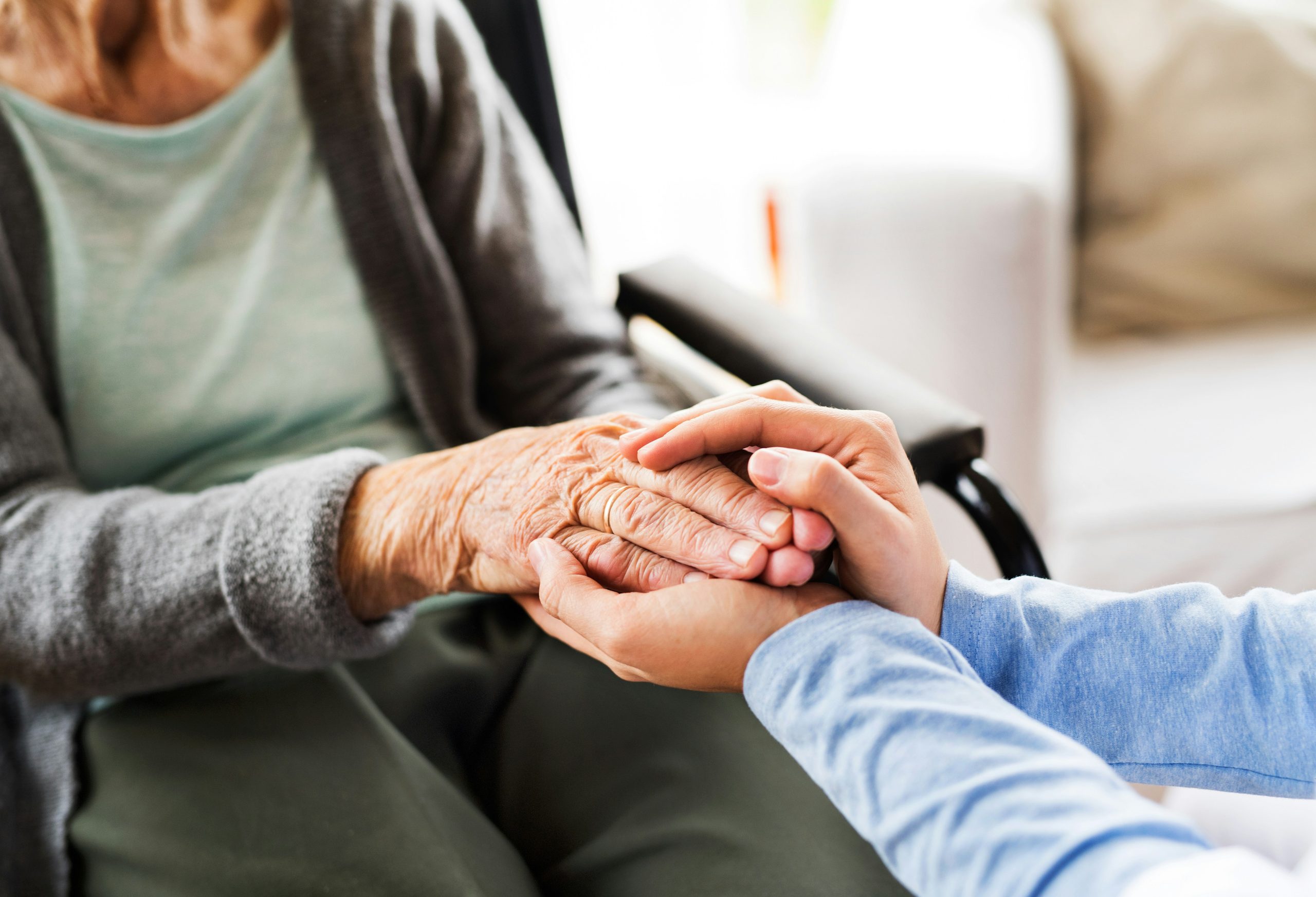 A caregiver offering gentle, comforting support to a senior resident